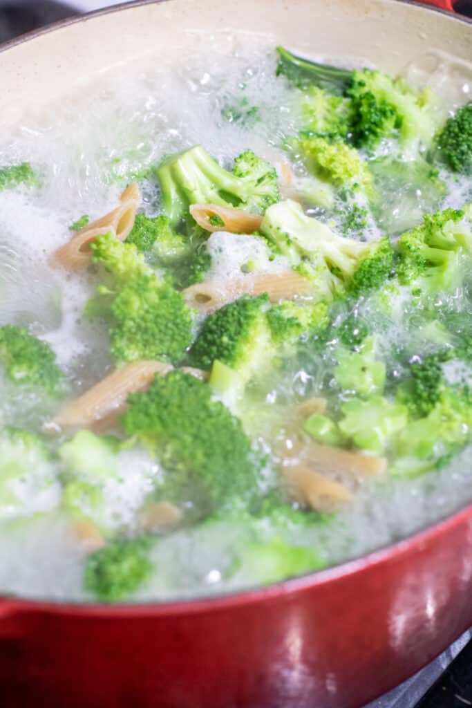 a pot with broccoli and penne boiling