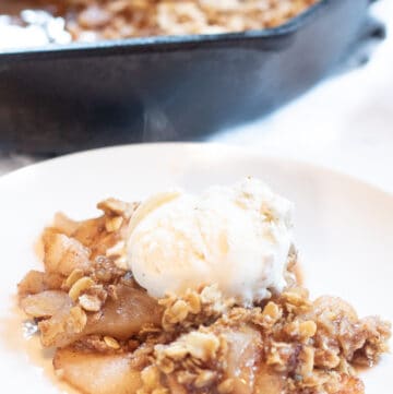 a plate of apple crisp with ice cream on top.