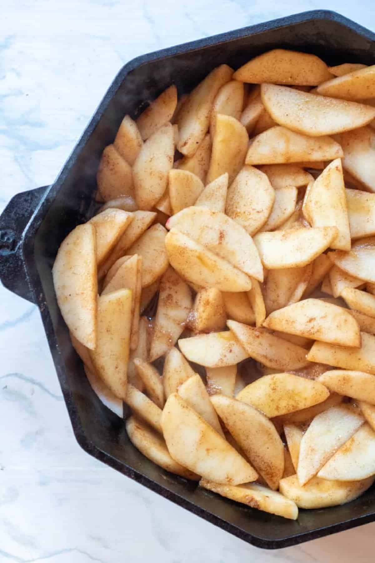 sliced spiced apples in a cast iron.