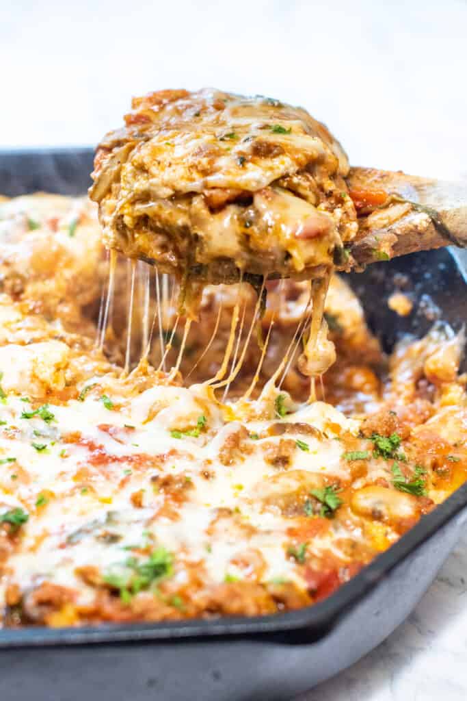egy öntöttvas serpenyőből előbújó lasagnaszelet