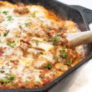 a cast iron lasagna with spoon in it.