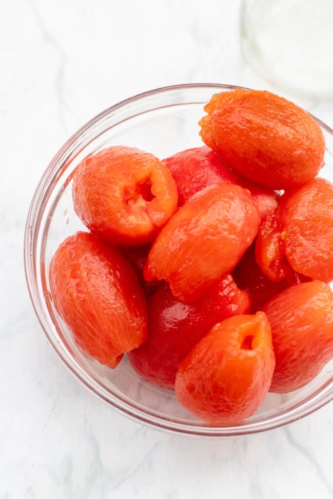 a bowl of skinned cooked tomatoes