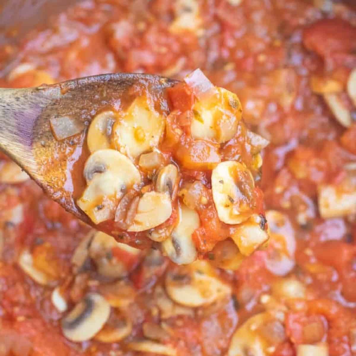 a wooden spoon with mushroom marinara.