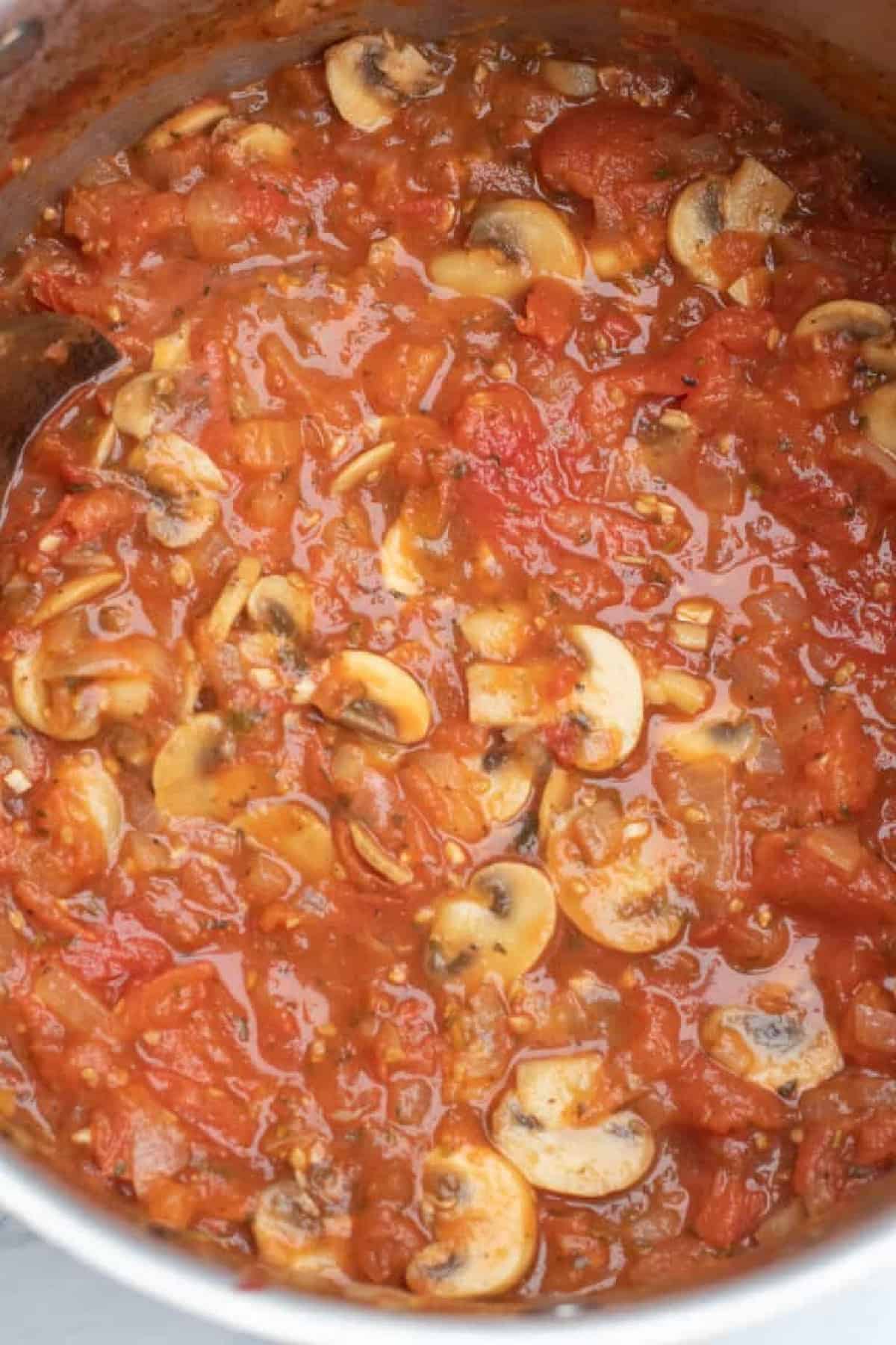 an overhead of a large pot with mushroom marinara.