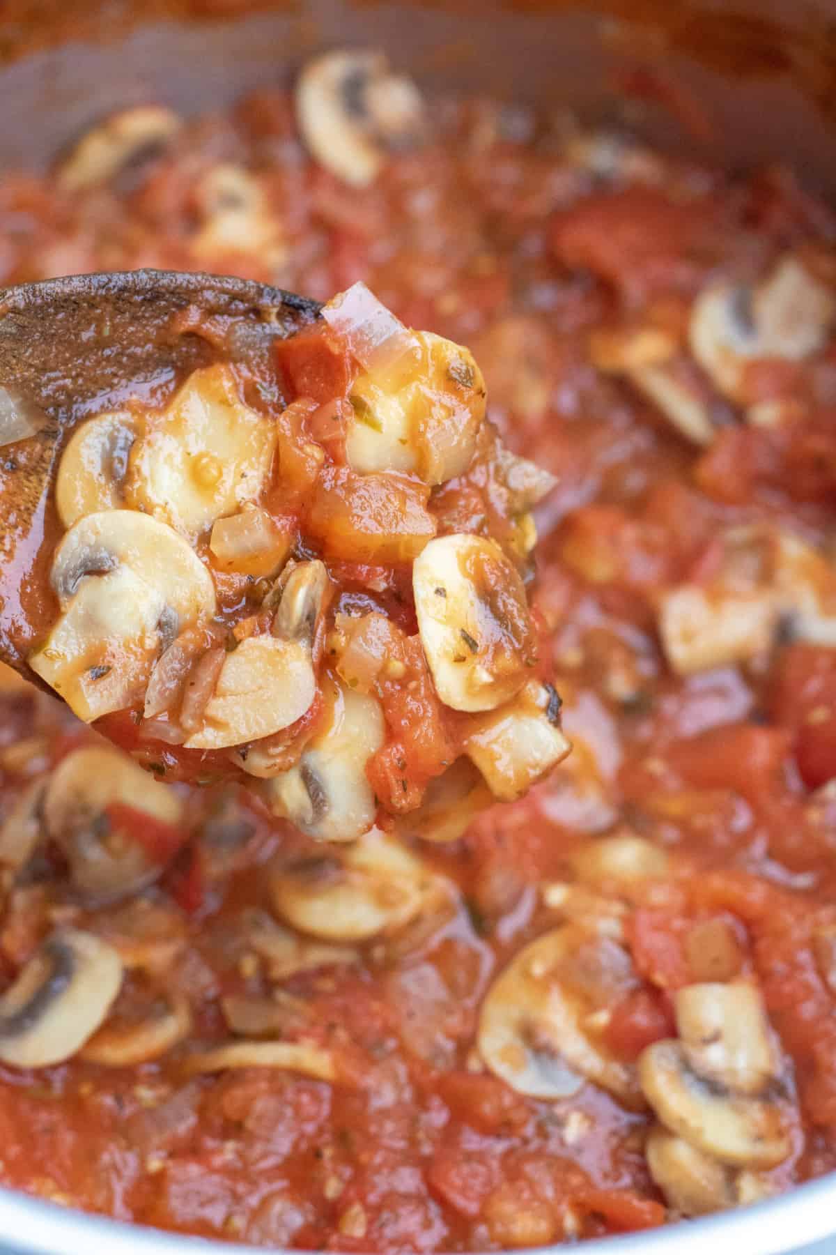 a wooden spoon with mushroom marinara.