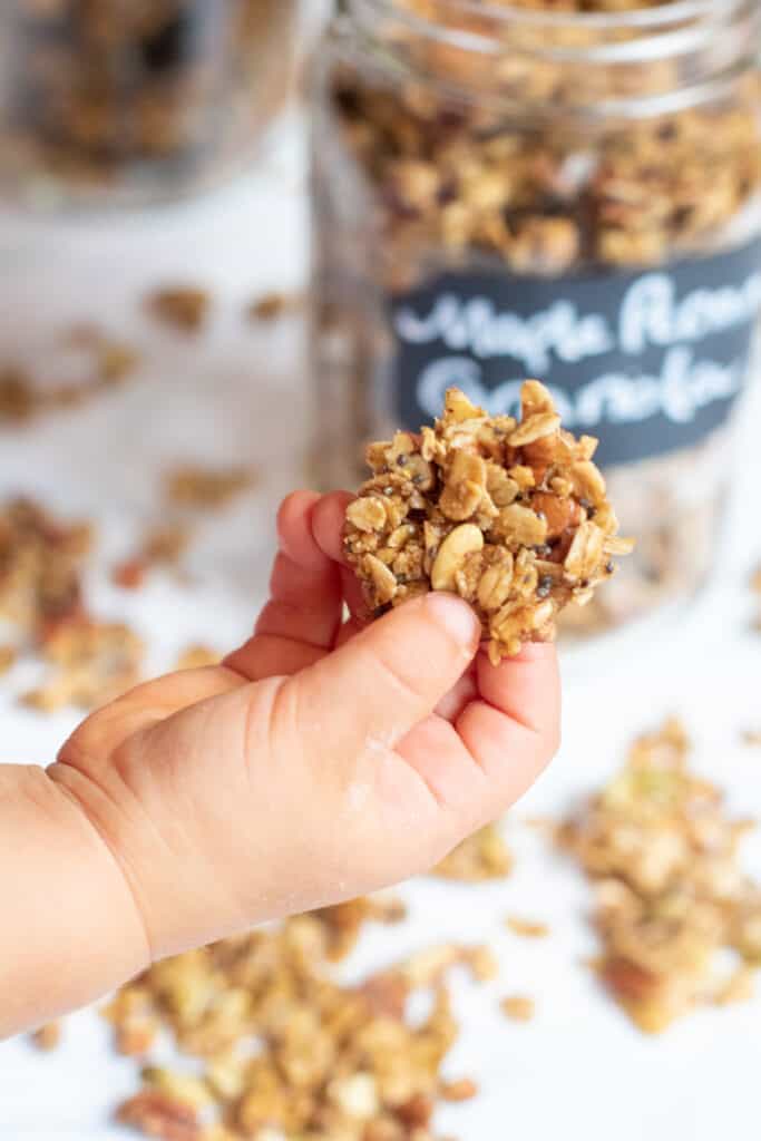 a toddler hand holding a granola cluster 