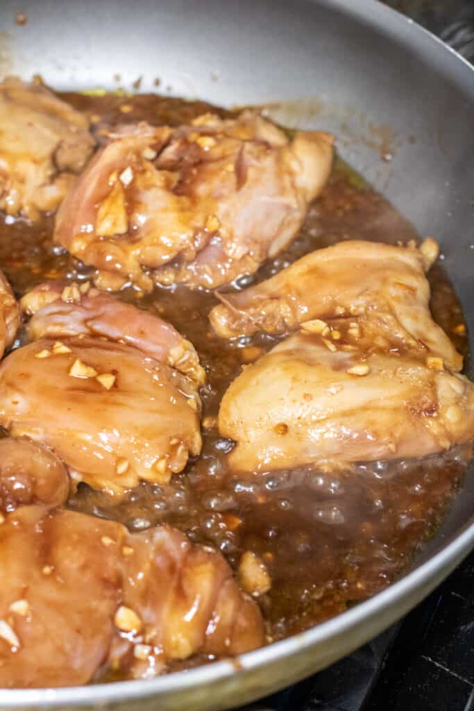chicken thighs cooking in a pan