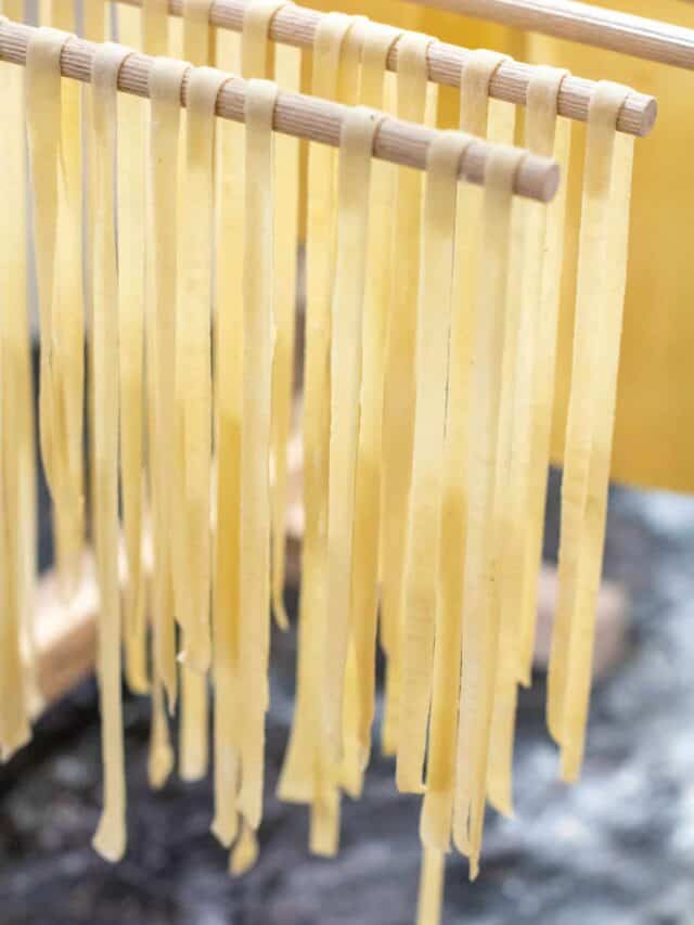 linguine pasta drying on a hanging rack.