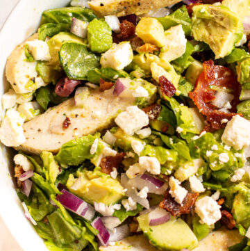 bowl of salad with chicken, feta, tomatoes.