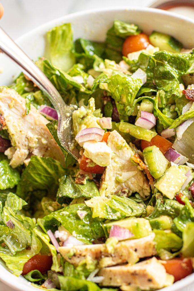 a bowl of salad with a fork in it.