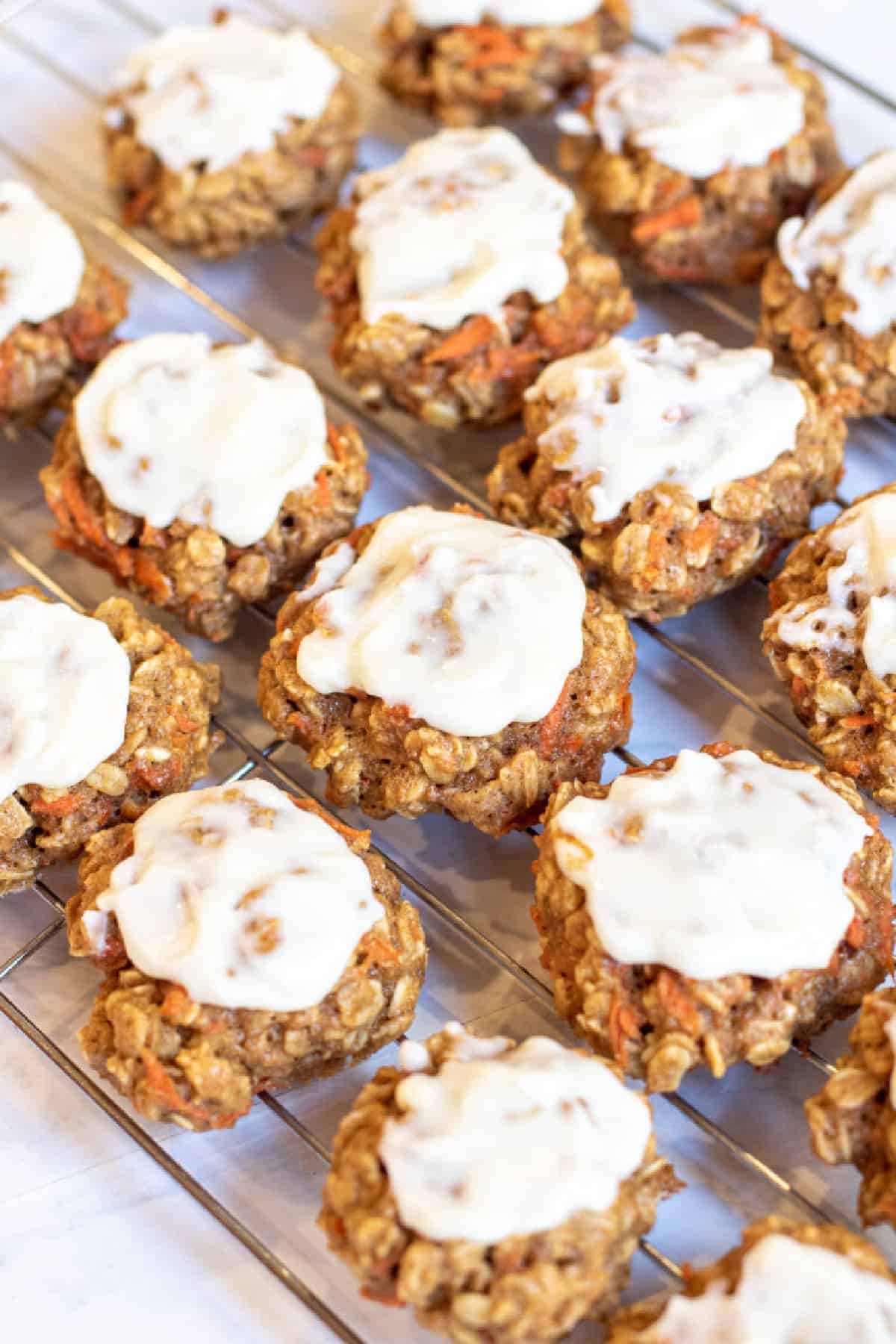 a cooling rack of frosting cookies.