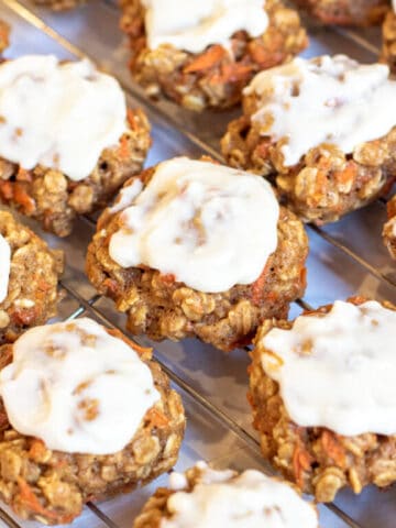 a cooling rack of frosting cookies.