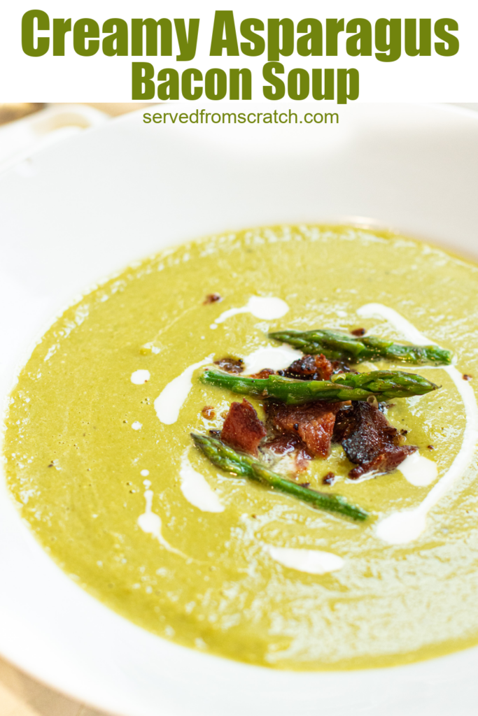 a close up of a bowl of creamy green soup with asparagus and bacon on top with Pinterest pin text.