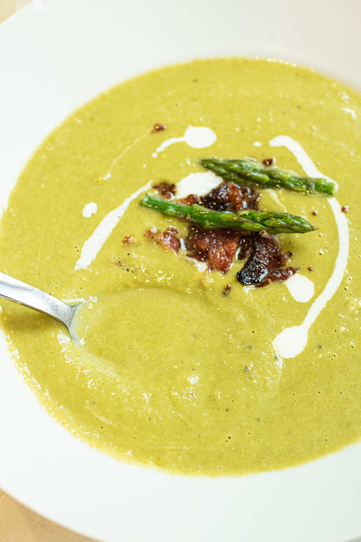 bowl of soup with bacon and asparagus and cream.