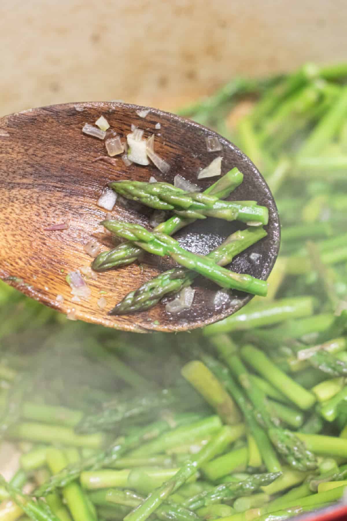 wooden spoon with cooked asparagus.