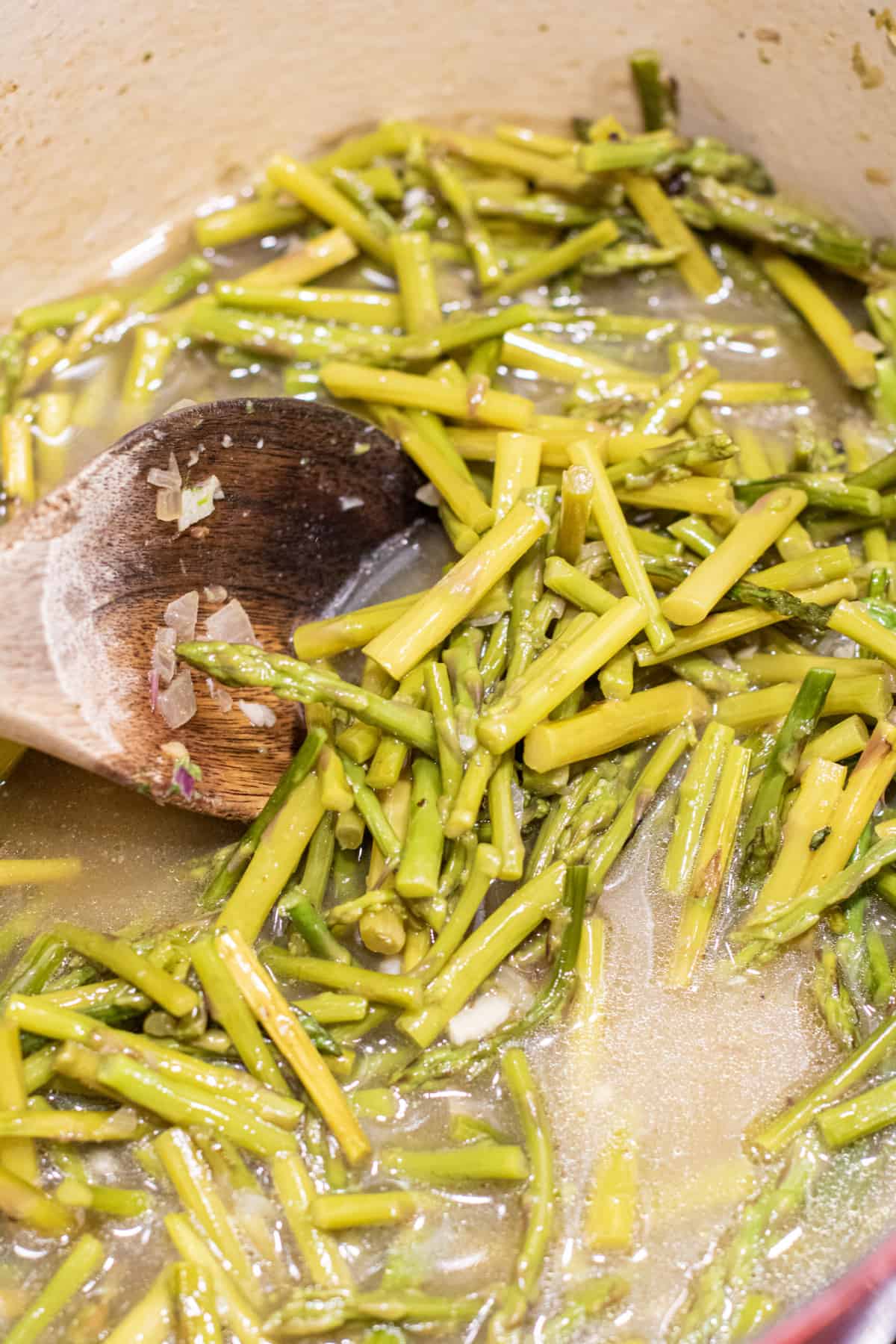 dutch oven with wooden spoon and cooked asparagus.