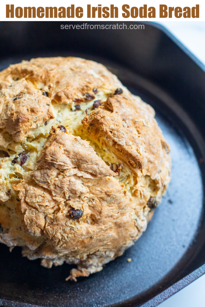 baked bred with raisins in a cast iron skillet and pinterest text.