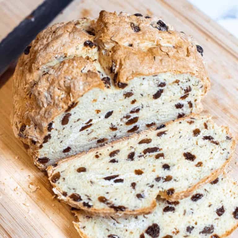 a loaf of raisin filled irish soda bread with slices cut off.