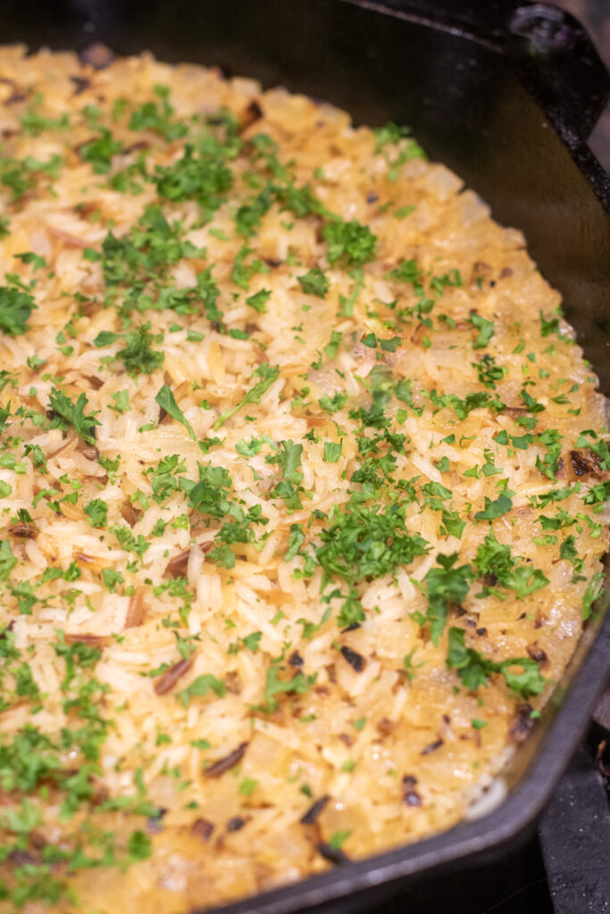 cooked rice pilaf in a cast iron topped with parsley