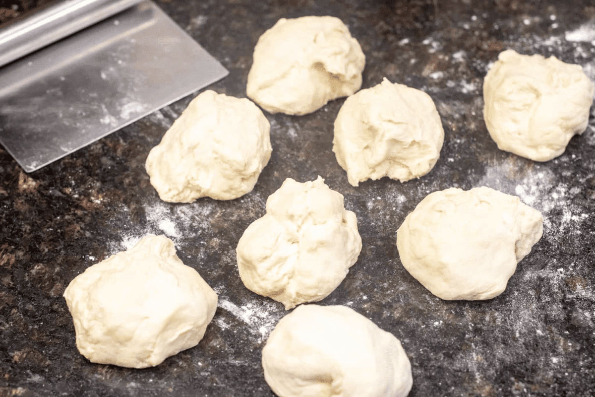 8 pieces of dough cut on a counter.