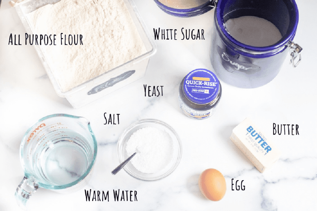 flour, sugar, water, egg, salt, yeast, butter, on a counter.