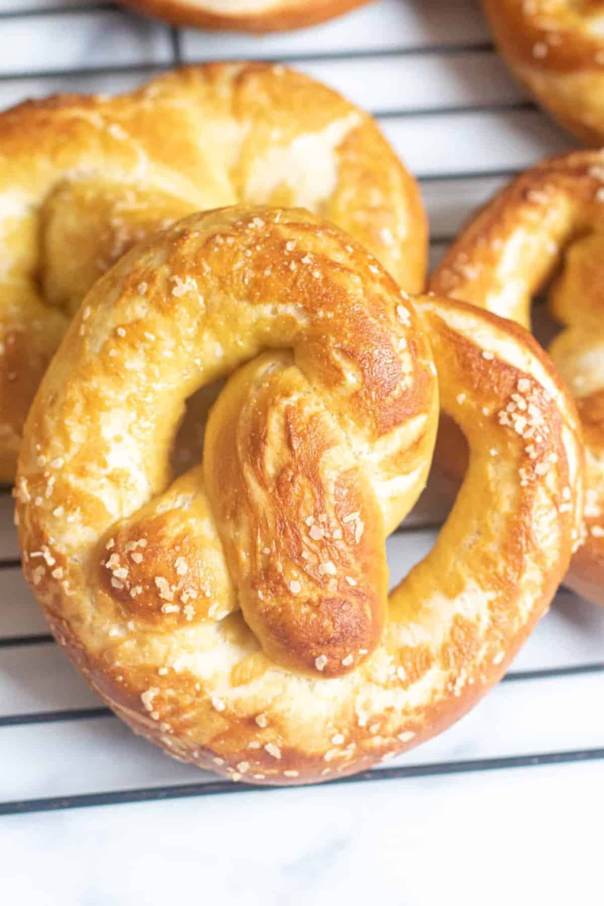 close up of a soft pretzel on a cooling rack.