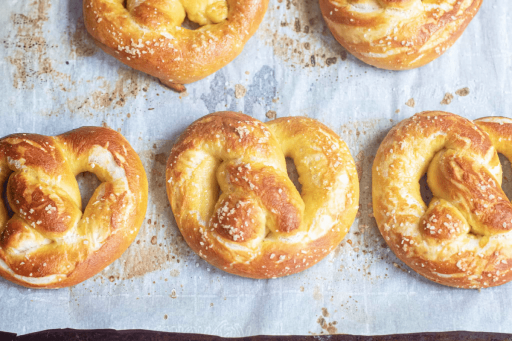fresh baked pretzels on a baking sheet.