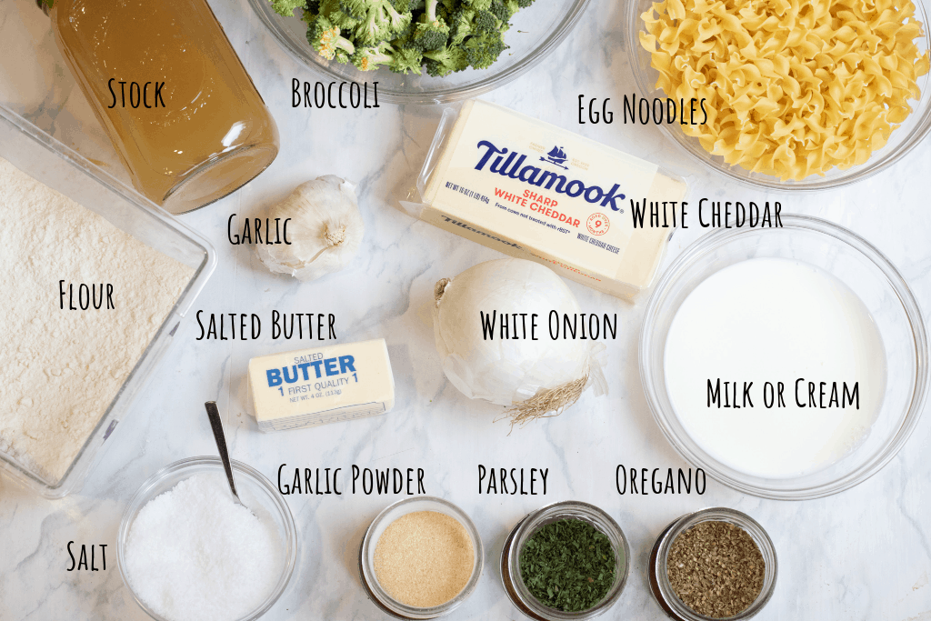 stock, flour, butter, noodles, broccoli, onion, garlic, milk, garlic powder, parsley, and oregano on counter