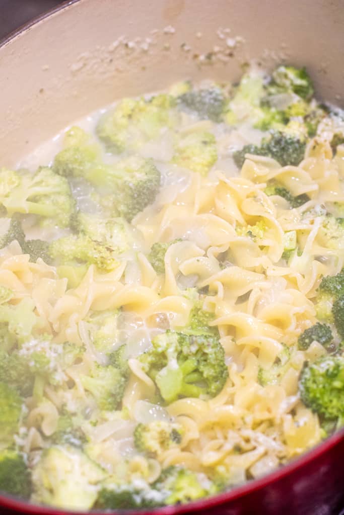 pasta and broccoli cooking in a pot.