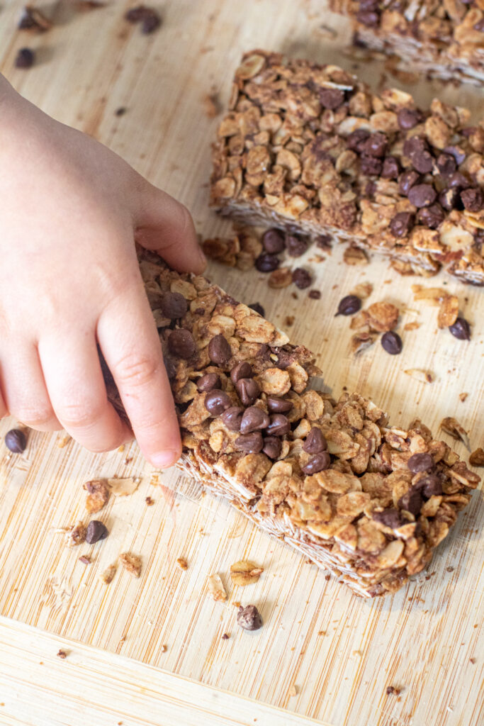 a toddler hand grabbing a granola bar.