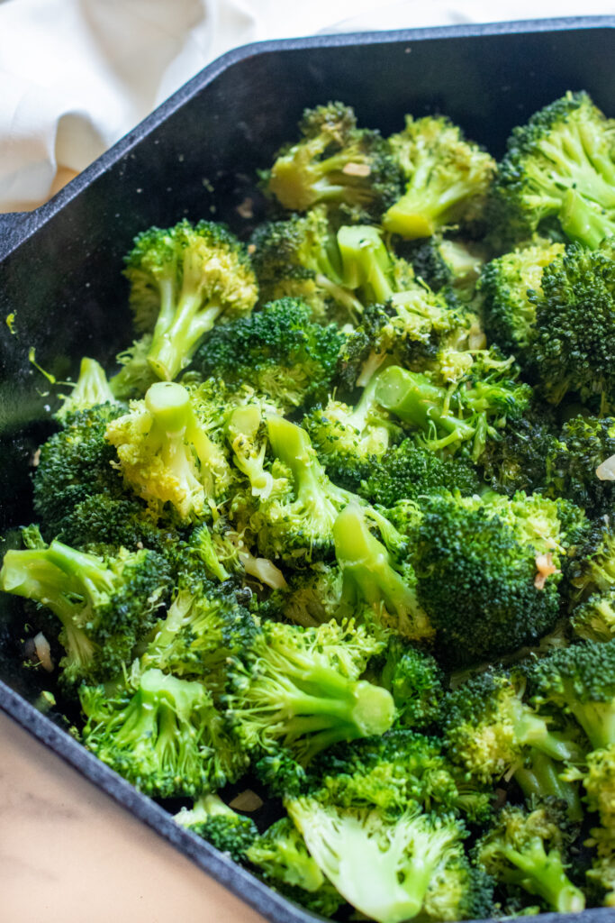 cooked broccoli and garlic in a cast iron