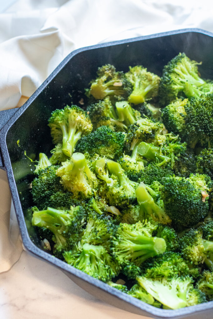 cooked broccoli and garlic in a cast iron