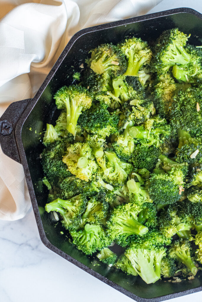 overhead of cooked broccoli and garlic in a cast iron