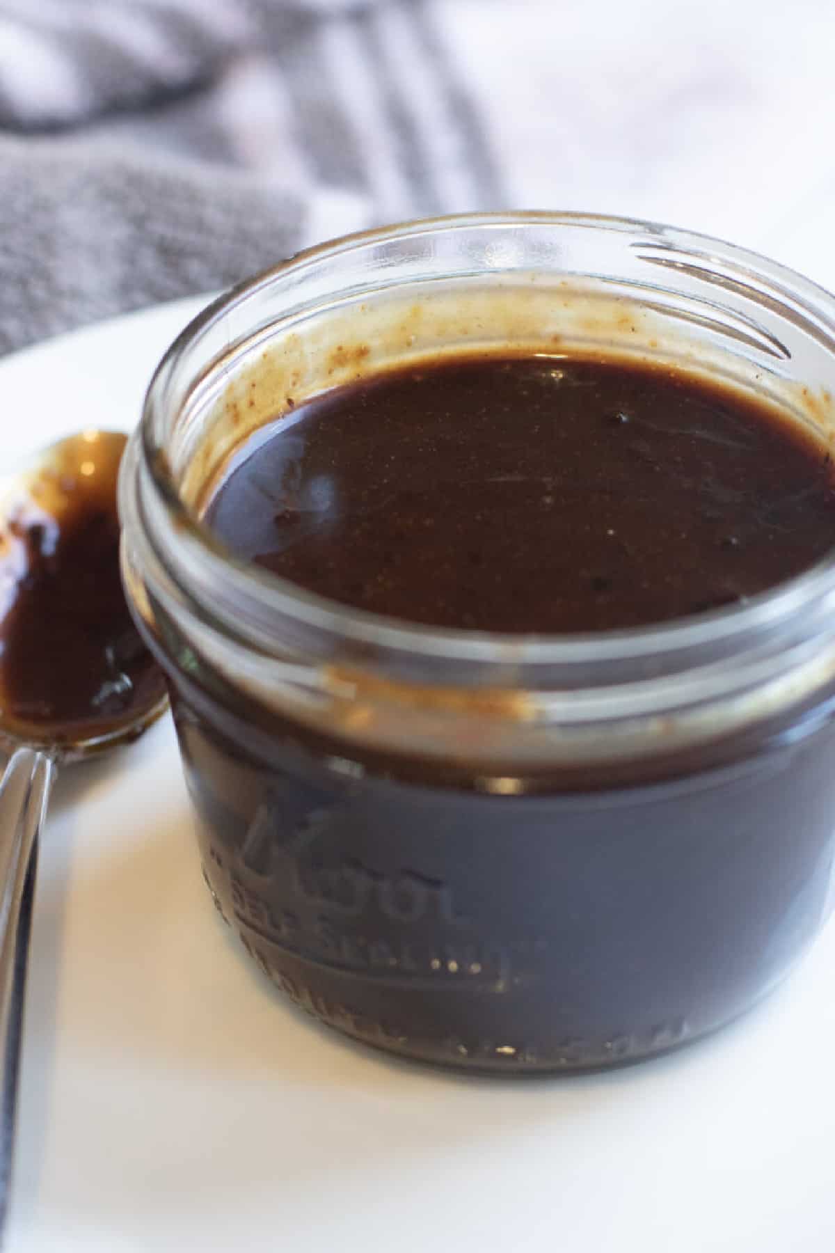 an open small mason jar of hoisin sauce.