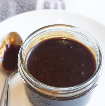 an open small mason jar of hoisin sauce.