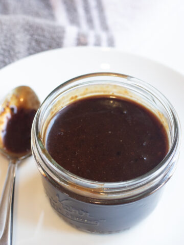 an open small mason jar of hoisin sauce.