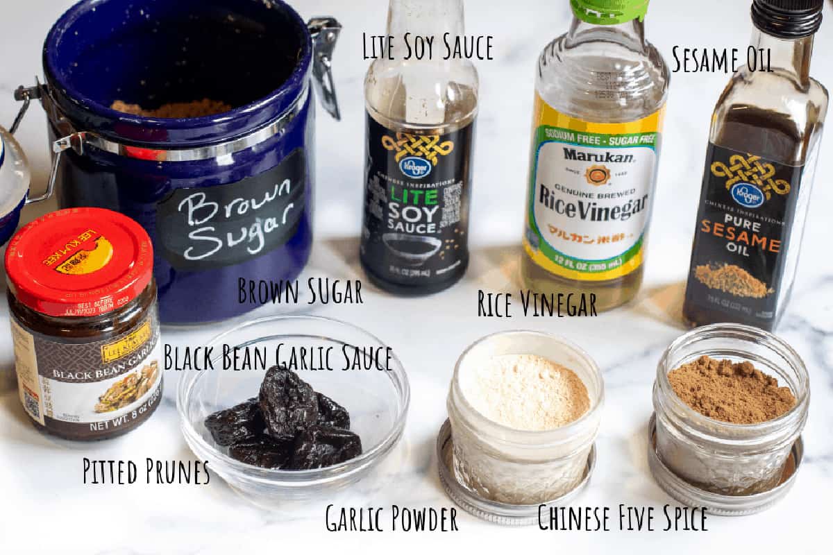 brown sugar, black bean paste, prunes, garlic, 5 spice, soy, vinegar, and sesame oil on a counter.