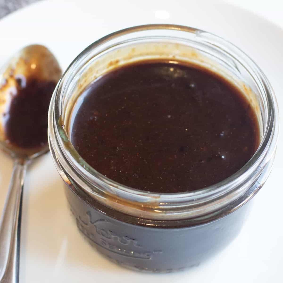 an open small mason jar of hoisin sauce.