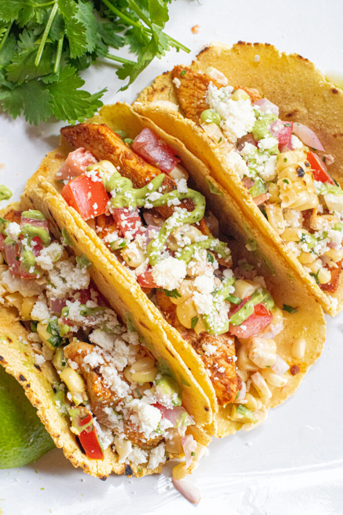 corn tortillas with grilled corn, cotija cheese, and avocado cream sauce.