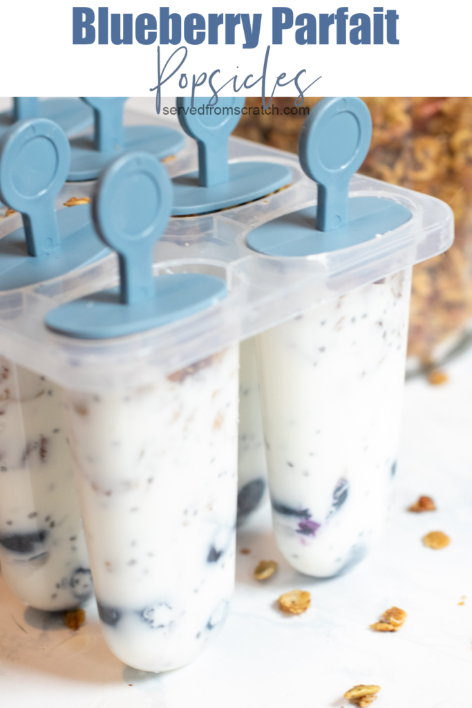 popsicle molds with yogurt blueberry parfaits in them with Pinterest pin text.