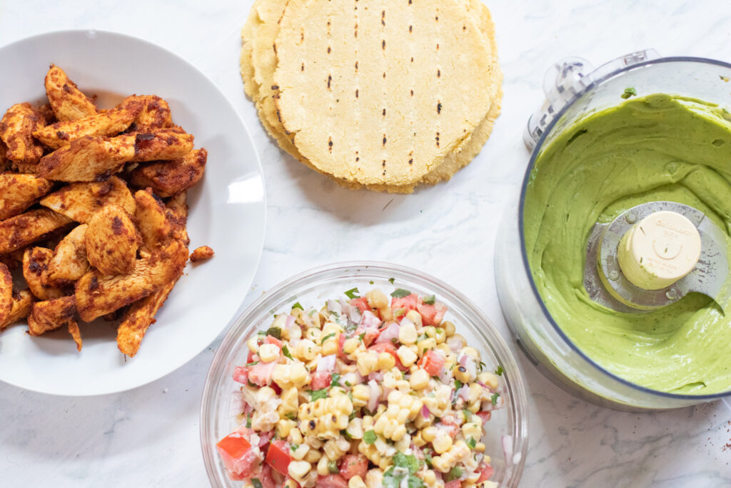 cooked chicken, corn tortillas, corn salad, and avocado cream.