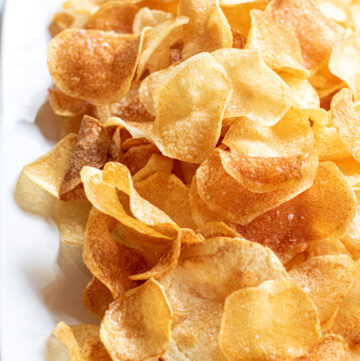 a plate of thin crispy potato chips.