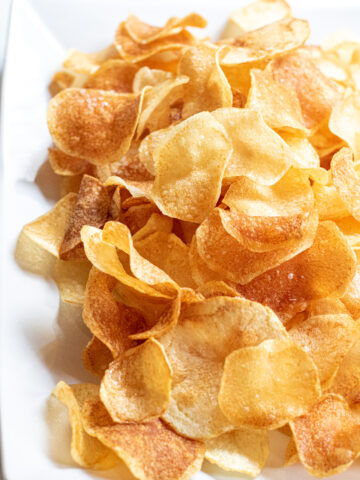 a plate of thin crispy potato chips.