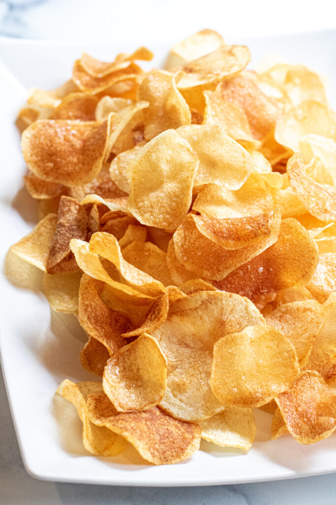 a plate of thin crispy potato chips.