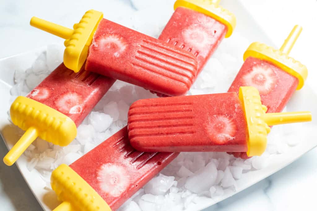 strawberry popsicles on a plate.