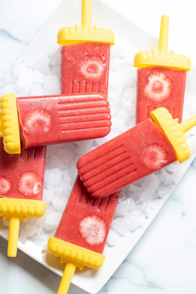 strawberry popsicles on a plate.