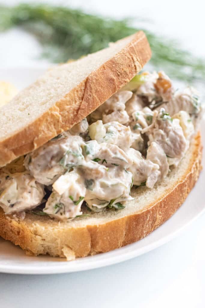 a stuffed sandwich with chicken salad on a plate with chips.