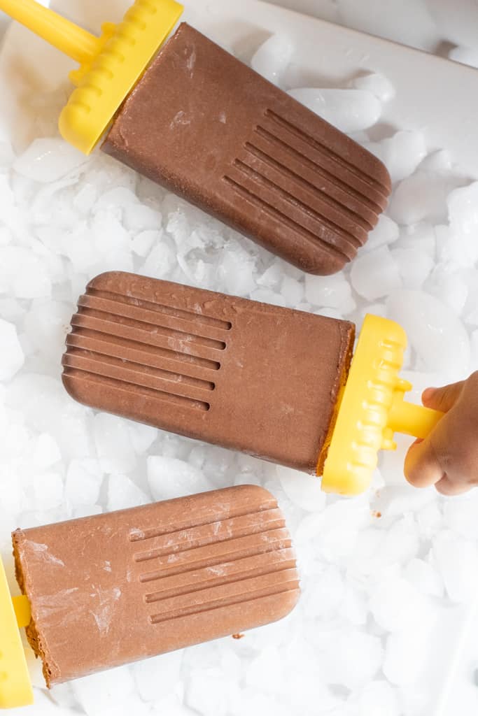 3 chocolate fudgesicles on a plate.