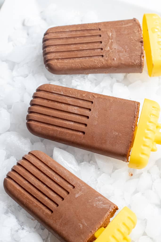 3 chocolate fudgesicles on a plate.