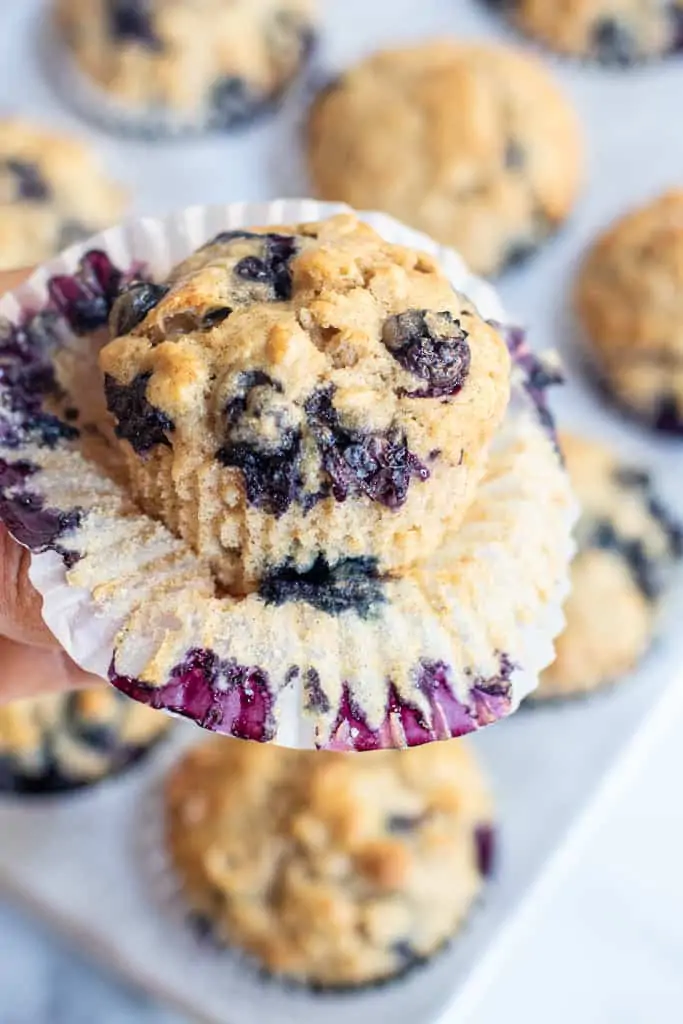 an opened muffin liner with a fresh muffin.